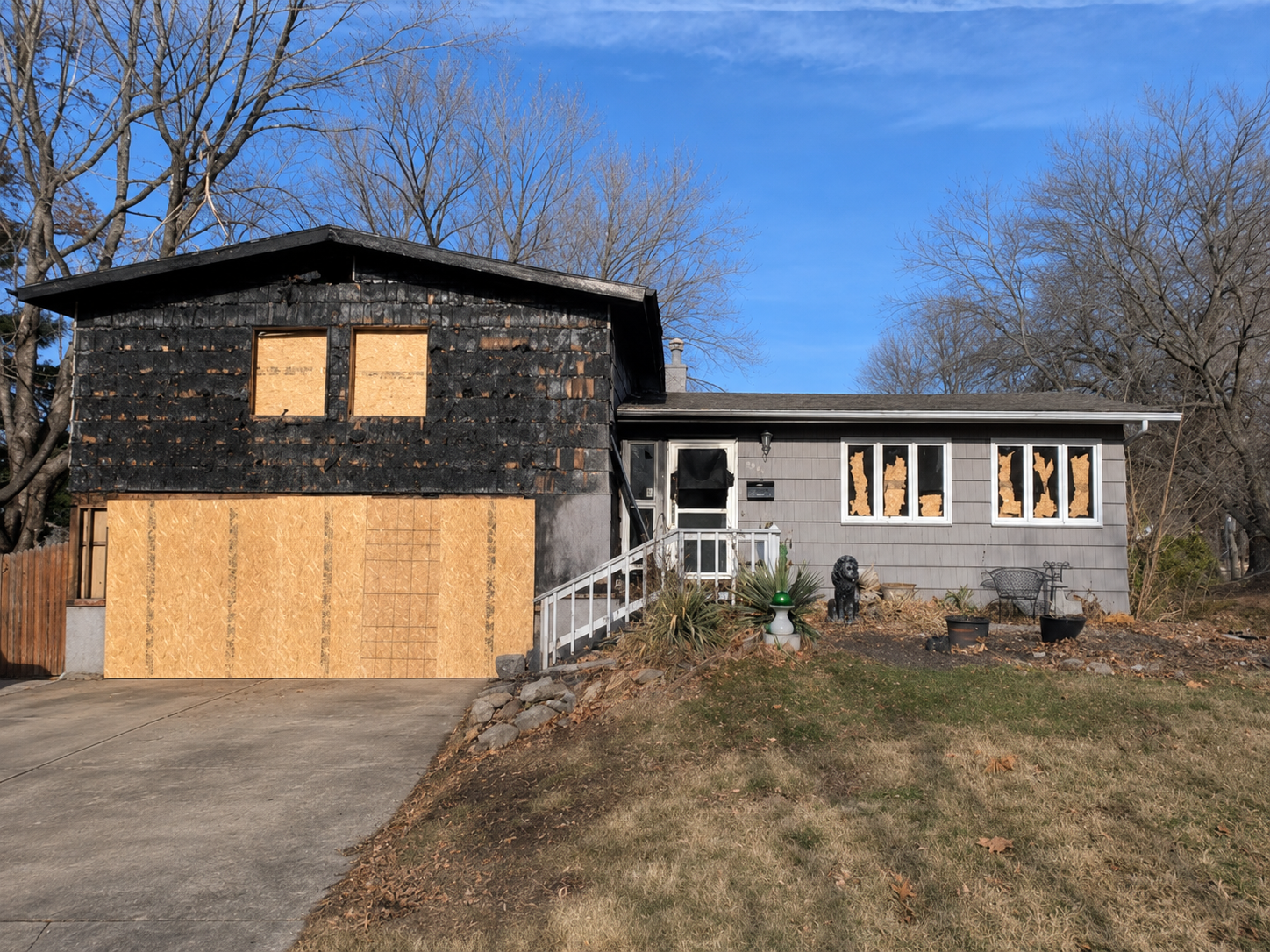 Fire-damaged house with boarded-up windows.