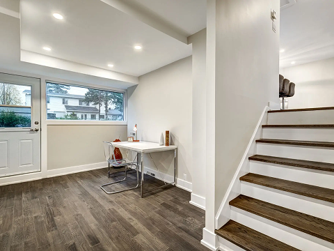 Modern room with stairs and large window.