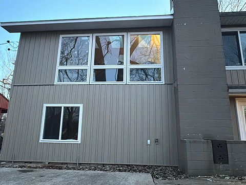 Modern house exterior with large windows.