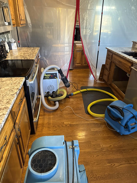 Kitchen under renovation with drying equipment present.