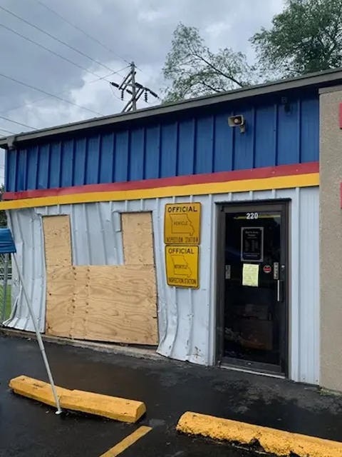 Damaged building with boarded-up window.