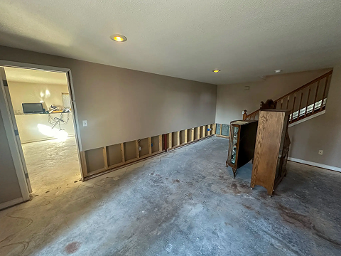 Unfinished room with exposed drywall and furniture.