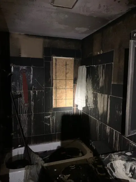Dark, abandoned bathroom with broken window.