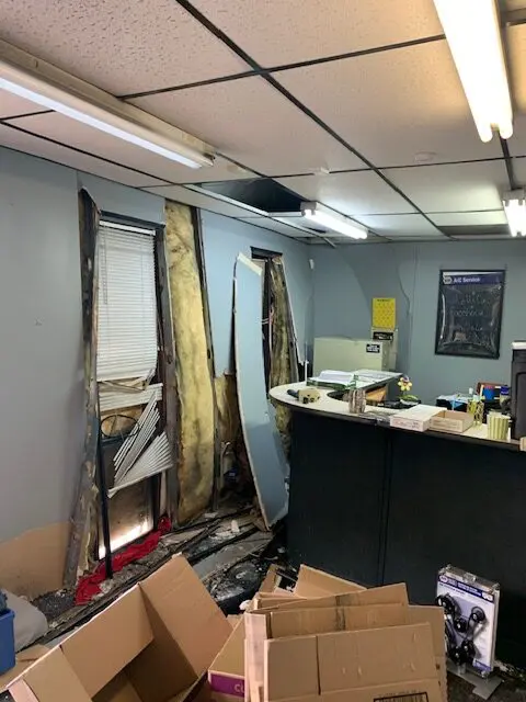 Damaged office with torn walls and ceiling.