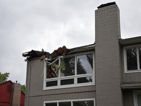 Damaged building roof with broken windows.