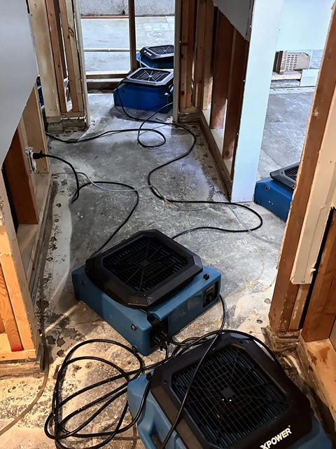 Drying equipment in a water-damaged room.