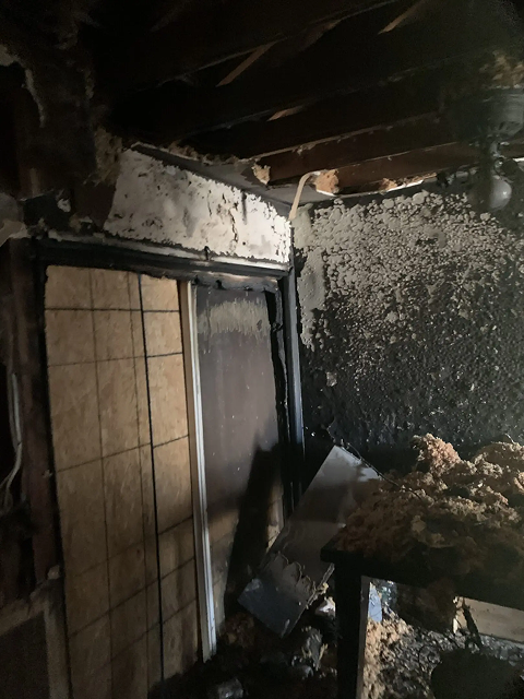 Burnt room with charred walls and debris.