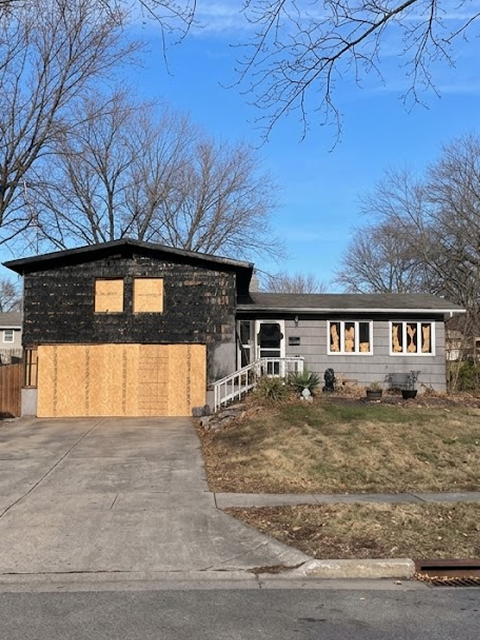 House with boarded windows and garage door.