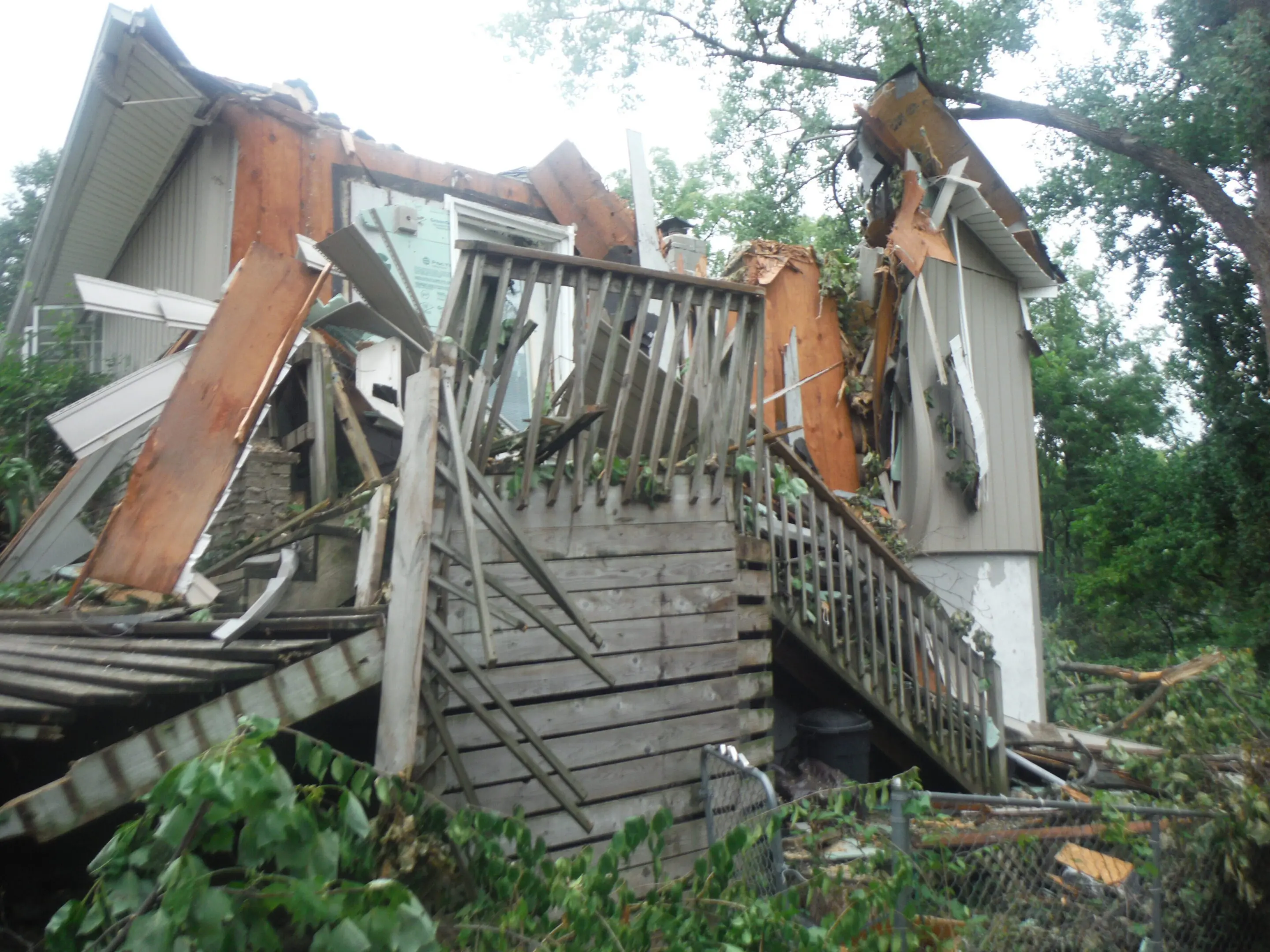 Collapsed house with debris and broken structure.